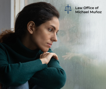 A woman with a tense expression looks through a window